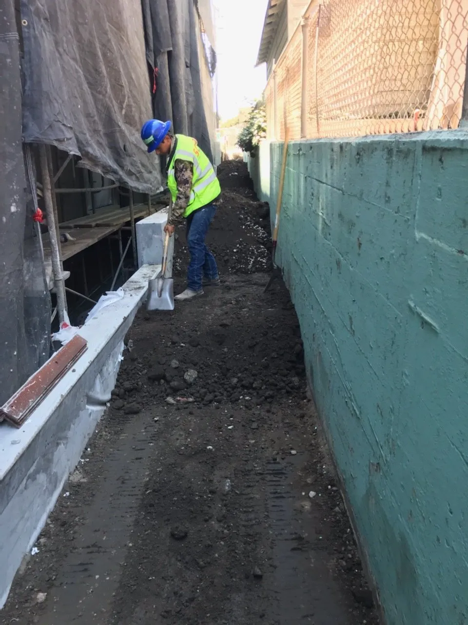 Backfilling compacted dirt between two concrete walls