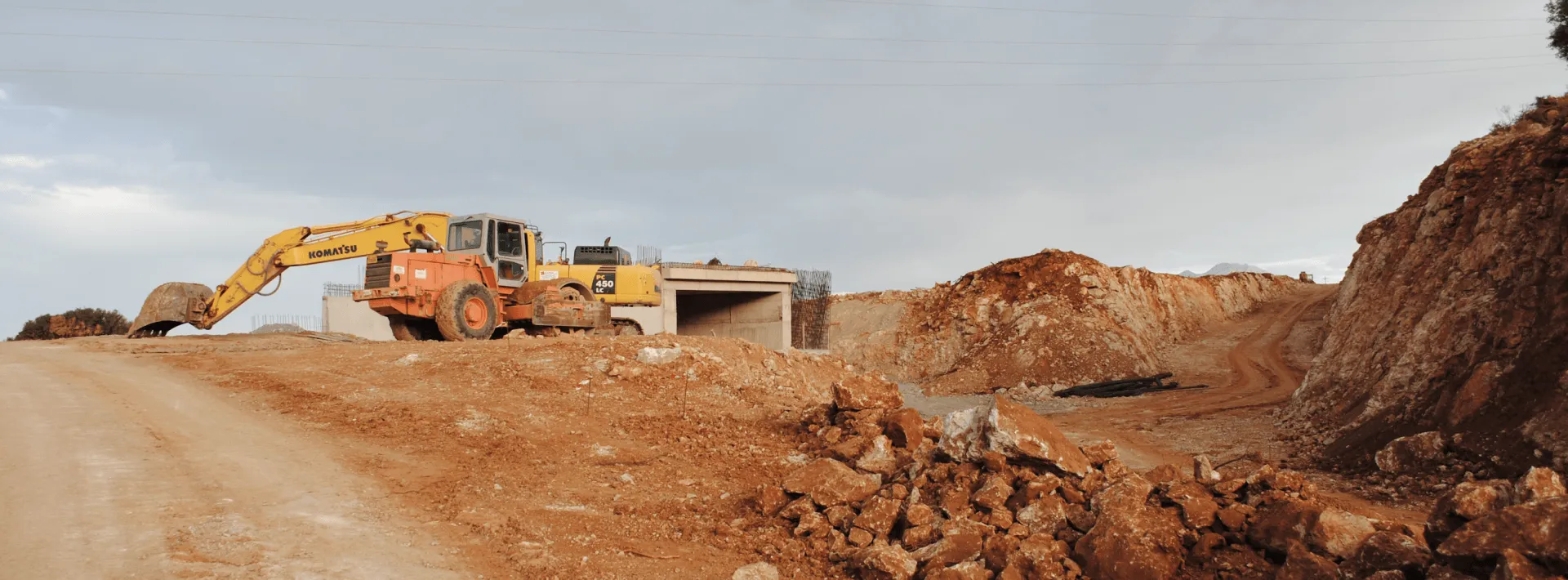 Excavator working a dirt-and-rock excavation site